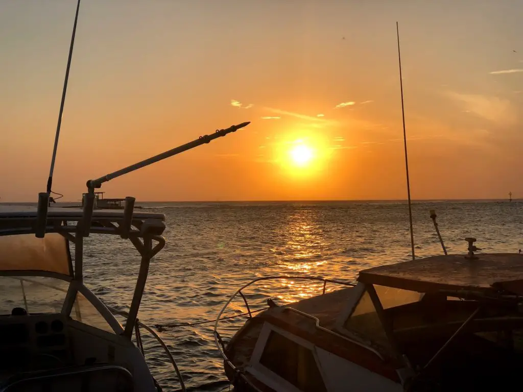 sunset with two boats at zeerovers restaurant aruba