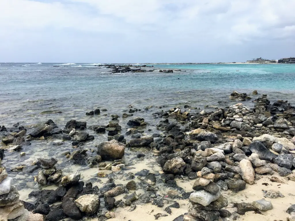 rocks and turquoise waters of baby beach for best beach day in aruba