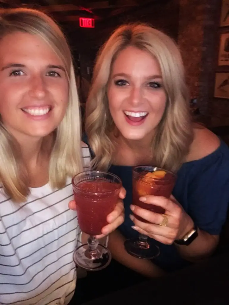 two girls drinking punch at succotash