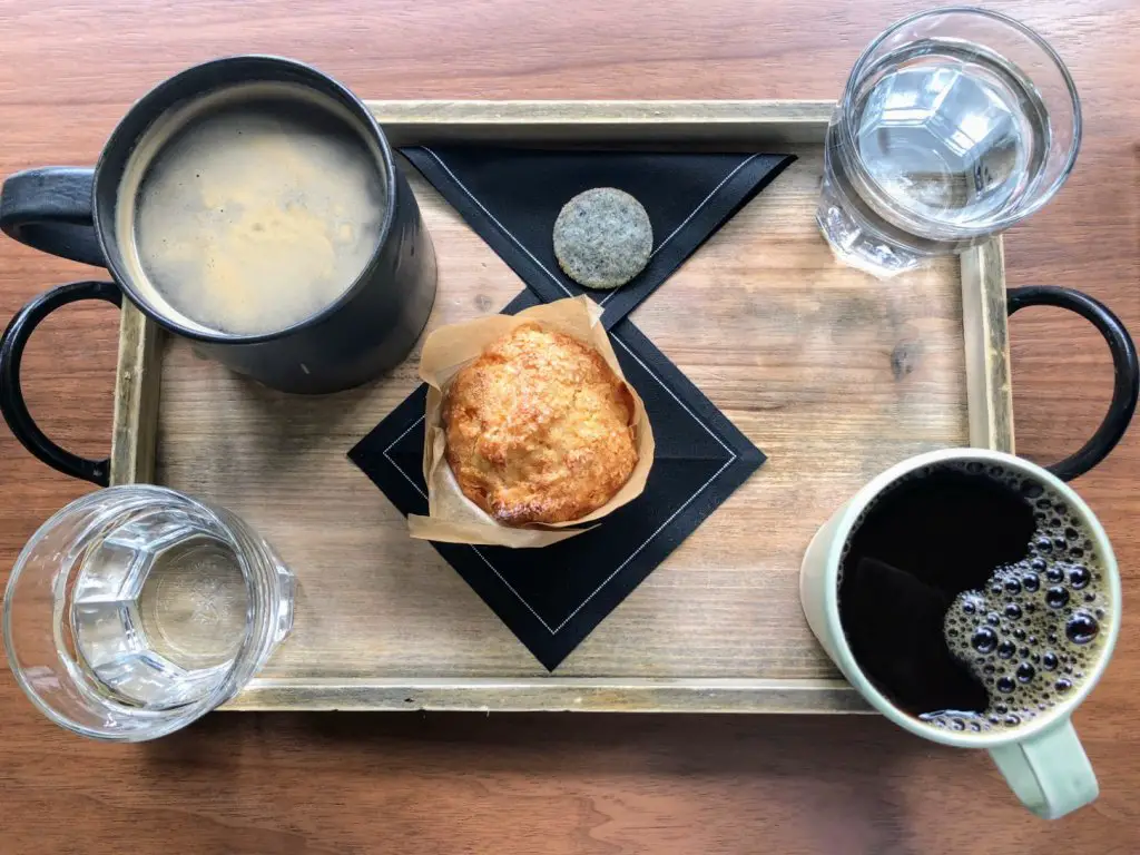 coffee tray with two coffees and a a muffin at kintsugi in the eaton hotel