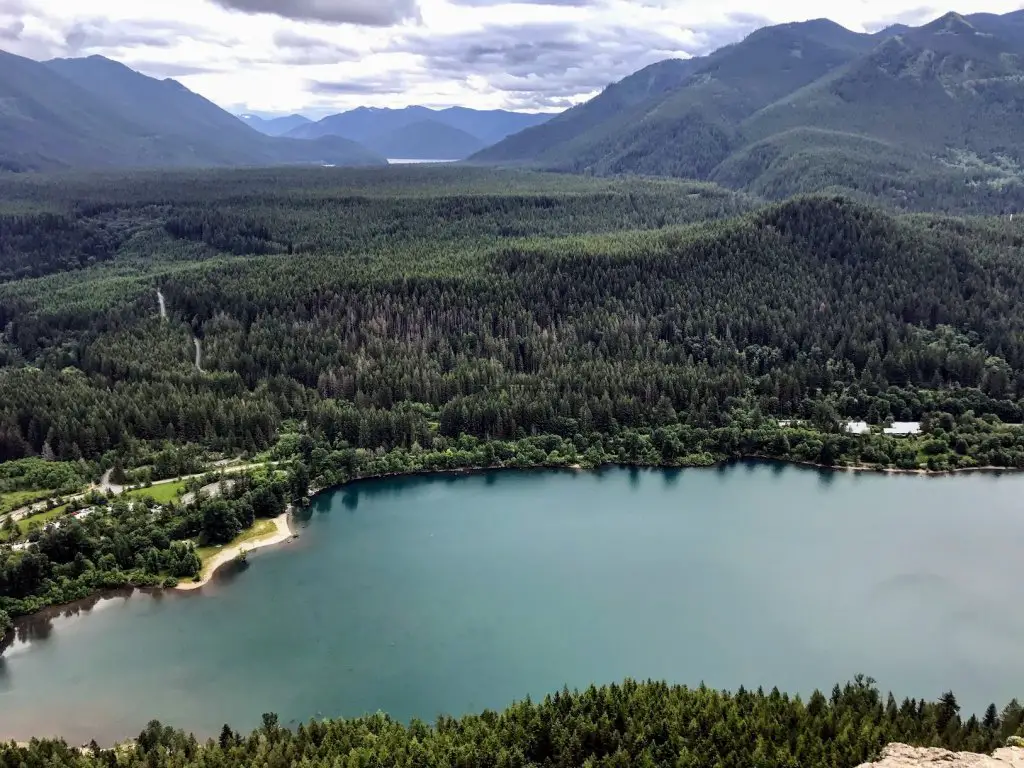 overlooking rattlesnake ledge with water below with a view of mountains, trees, and clouds 