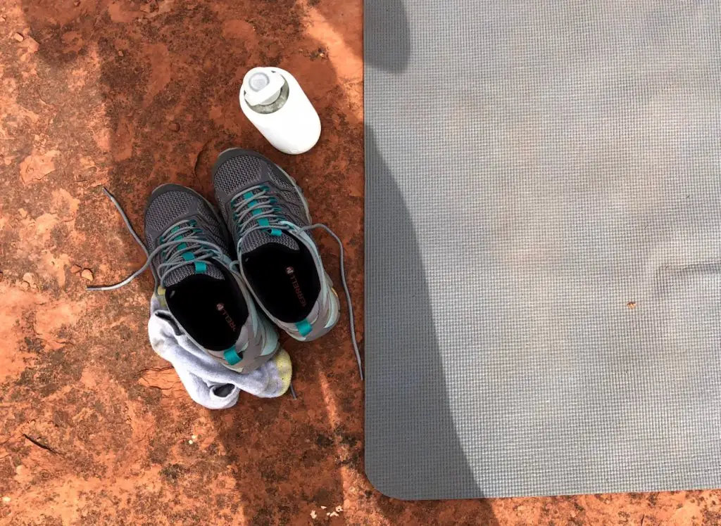 hiking shoes, water bottle, and yoga mat on the red rocks