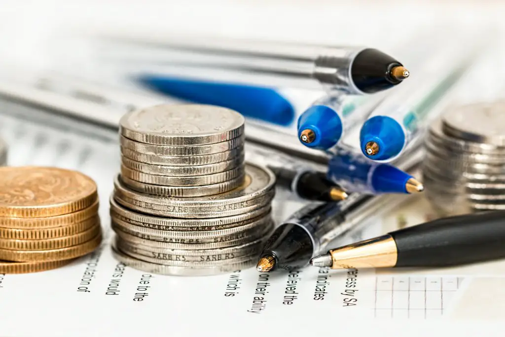 coins and pens stacked up for budgeting