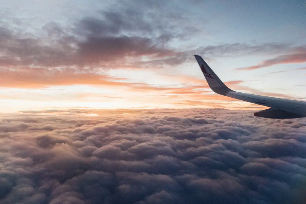 airplane wing in the sky with clouds after save to travel