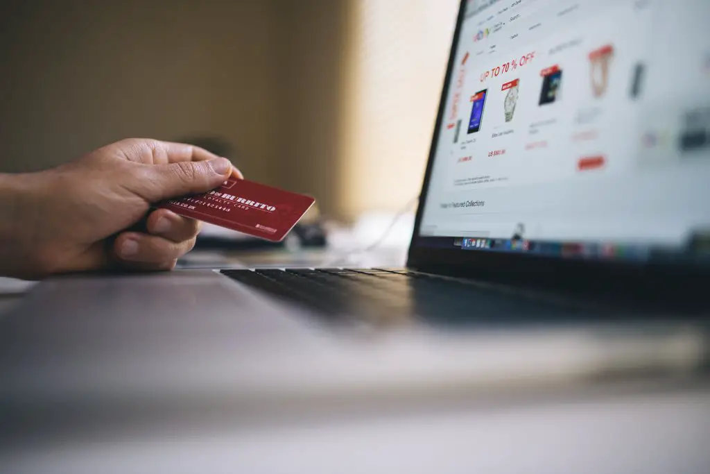 guy purchasing items online with credit card in hand